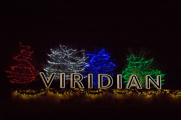 The Viridian sign is surrounded by winter lights on trees.