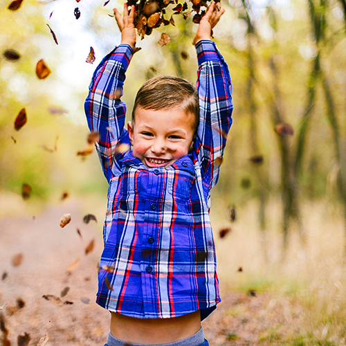 Child playing in leaves near new homes in Arlington, TX.