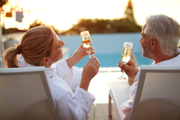 Couple toasting champagne glasses by the pool